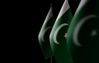 Small national flags of the Pakistan on a black background - obrazy, fototapety, plakaty