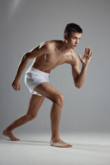 Obraz premium man doing sports indoors in white shorts leaning forward