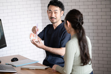 患者さんに模型を使って歯ブラシの指導をする歯科のドクター2
