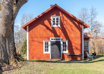 Front of a red wooden farmhouse painted in a traditional swedish color. - 427587073