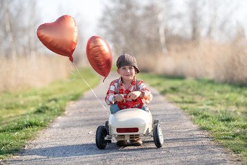 lachender Junge im Tretauto