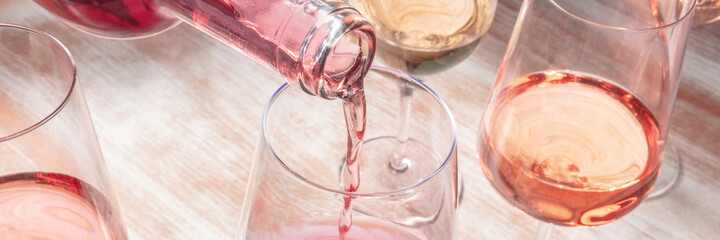 Rose wine pouring panorama with various glasses - obrazy, fototapety, plakaty