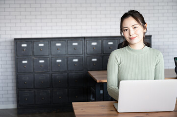 パソコンを使いながら仕事をする笑顔が美しい若い日本人女性3...