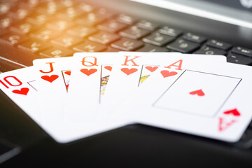 Online gaming platform, casino and gambling business. Poker cards on laptop keyboard