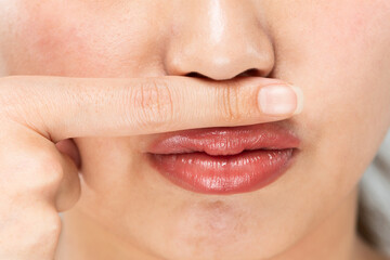 Obraz premium 鼻の下に指をおく女性