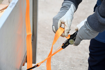 Action non focus fixing trailer strop or strap in orange nylon and metal, object helping for...