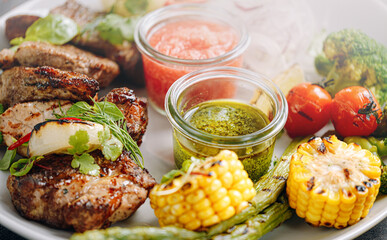 shish kebab and vegetables grilled and served on a white plate