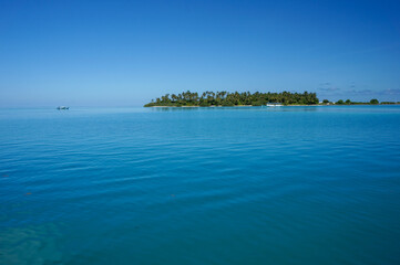 Uninhabited tropical island with palm trees. empty space with beautiful turquoise lagoon