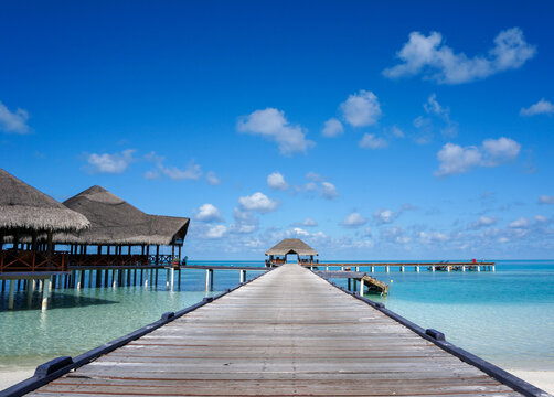 Wooden pier leading water bar on indian ocean in the Maldives. turquoise lagoon