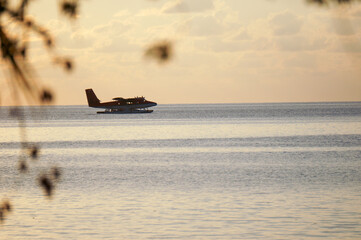 landing of a seaplane on the maldivian lagoon at sunset. luxurious travel concept © mathilde