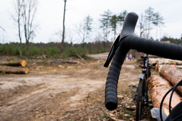 Adventure on a gravel bike in the woods. View of the bicycle handlebar with accessories. Taken under cloudy skies