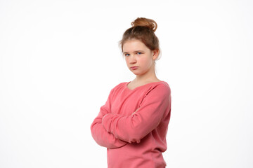 Photo of offended young girl posing isolated on white background. Holding hands crossed, looking at...