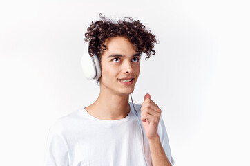 Cheerful man with curly hair in headphones listens to music emotions