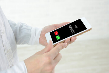 非通知設定での着信中のスマホと人物の手