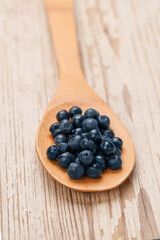 Fresh blueberries in wooden spoon on white vintage background. Healthy eating