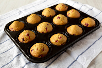 Homemade Cranberry Muffins with Orange Zest in a baking pan, side view.