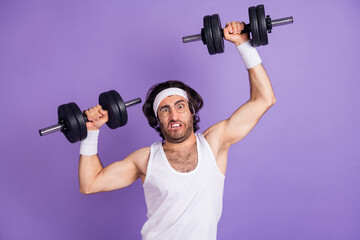 Plakat Photo of young funky funny crazy man in glasses lifting heavy dumbbell building muscles isolated on violet color background