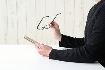 老眼イメージ―眼鏡をはずしてスマホを見る男性