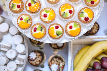 Fruit cupcakes decoration on a plate with cakes and fruits in the background