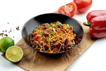 Classic Asian street food - udon wok noodles with pork, vegetables in sweet and sour sauce, served...