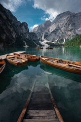 Obraz premium Lake Braies (Lago di Braies) in Dolomites Mountains, Boat hut on Braies Lake with Seekofel mount on background, Sunrise of Italian Alps, Naturepark Fanes-Sennes-Prags, Dolomite, Italy, Europe. 