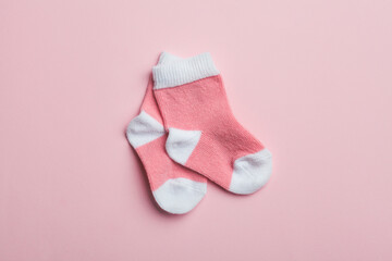 Pair of pink baby socks on pastel background