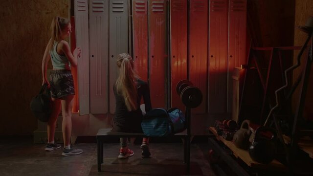 Girl get ready for boxing training in the locker room. Red Neon light