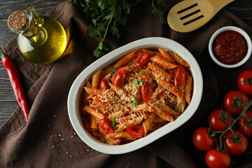 Tray with pasta with tomato sauce on wooden table, top view