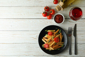 Concept of tasty food with pasta with tomato sauce on white wooden table