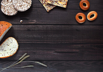 Bread, rice cookies and spikelets. Top view, place for text. Banner. A piece of bread on a dark wooden background. Flat lay, top view. place for text.