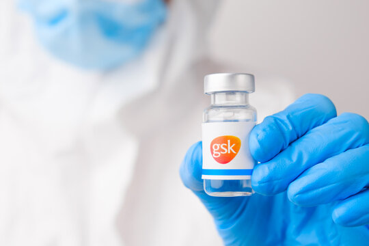 GSK vial or bottle with pharmaceuticals demonstrated by health worker or scientist in rubber gloves, April 2021, San Francisco, USA 