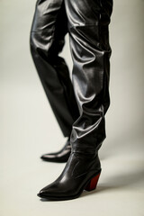 female legs in leather pants and leather boots