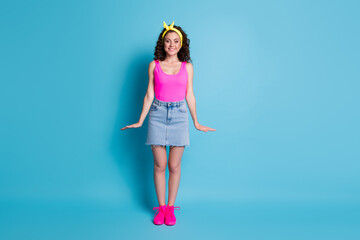 Photo of excited charming young lady wear pink singlet arms sides smiling isolated blue color background