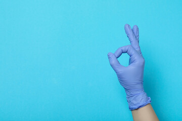 Hand in medical glove show OK on blue background
