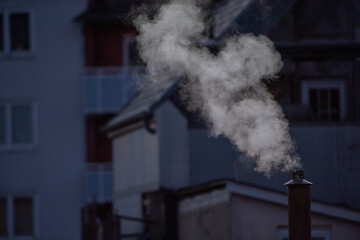 Ein rauchender Schornstein in kühler , urbaner  Umgebung  