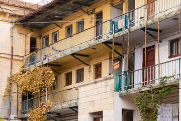 Naklejka premium Shared balconies in Sevastopol courtyards. Preserved courtyards with climbing vines. Pleasant autumn in Sevastopol.
