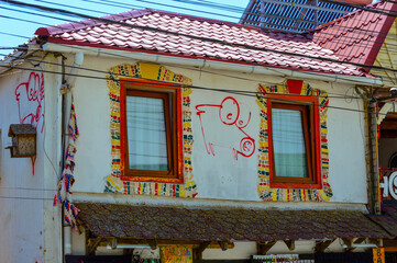 Old traditional building facade  eroded by time and vandalised with graffitty at Vama Veche,...