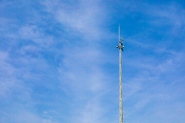 気象観測機器を取り付けた柱と青空