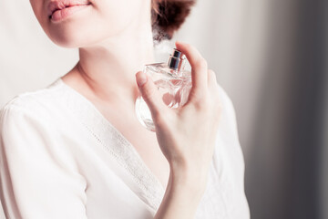 girl sprays herself perfume on her neck