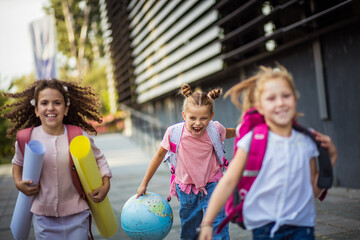 Joyful school children running outside.