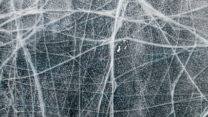 Methane Bubbles in Cracked Frozen Ice Surface at Baikal Lake in Russia in Winter. Aerial Top View