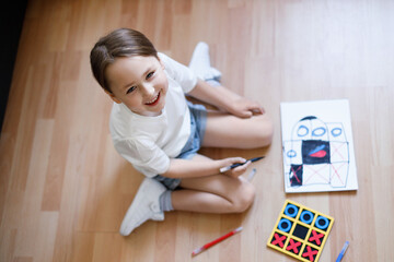 Little girl happily shows her drawing