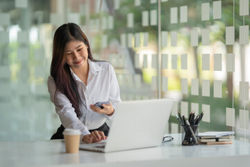 Portrait of a pretty young woman using her laptop in the office.