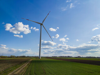 Fototapeta premium windmills in a green field against a blue sky