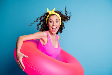 Photo of young excited girl happy positive smile hold pink float circle ready swim isolated over blue color background
