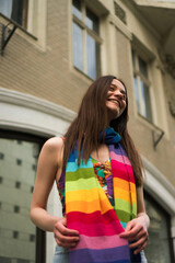 A young woman posing with the accent on rainbow colors scarf.