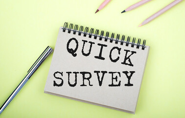 Quick Survey text written on a notebook with pencils