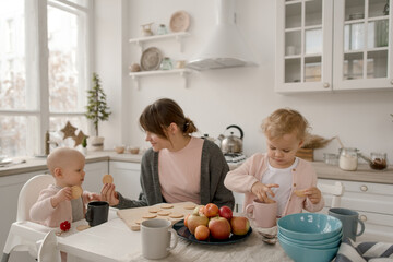 A young mother spends time with her little daughters at home.