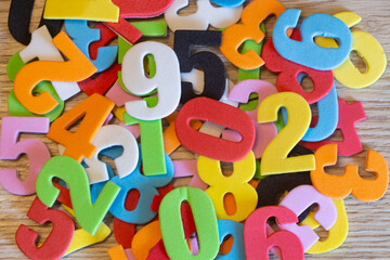 Multicolored numbers in foam on wooden background