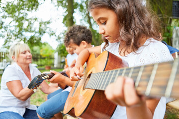 Kinder üben Gitarre spielen im Gitarrenkurs